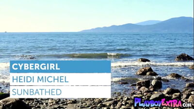 Big tits nude Canadian cybergirl Heidi Michel taking sunbath at the beach